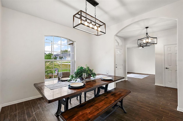 dining area featuring dark wood-type flooring and ceiling fan with notable chandelier