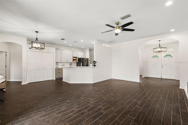 14701 Timucua Pl, Clermont, FL 34711 - unfurnished living room with arched walkways, a chandelier, a ceiling fan, dark wood-type flooring, and recessed lighting