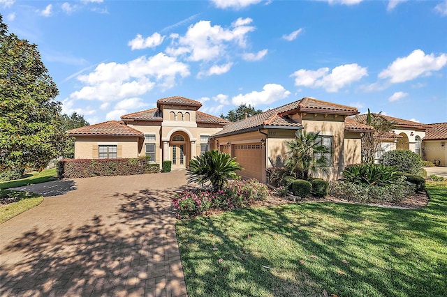 mediterranean / spanish house featuring a front yard and a garage