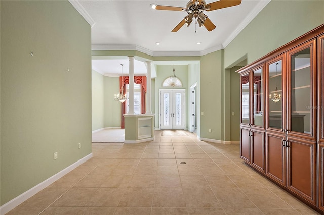 tiled entryway with ceiling fan with notable chandelier, ornate columns, crown molding, and french doors