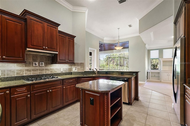 kitchen with appliances with stainless steel finishes, dark stone counters, sink, light tile patterned floors, and a kitchen island