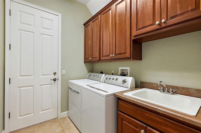 washroom with cabinets, light tile patterned floors, sink, and washing machine and clothes dryer