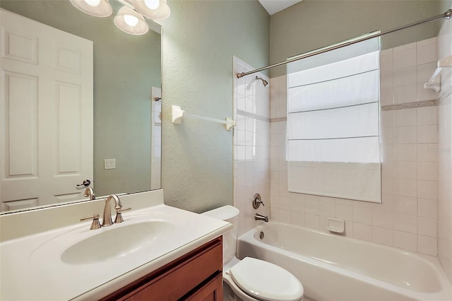 full bathroom featuring vanity, tiled shower / bath combo, and toilet