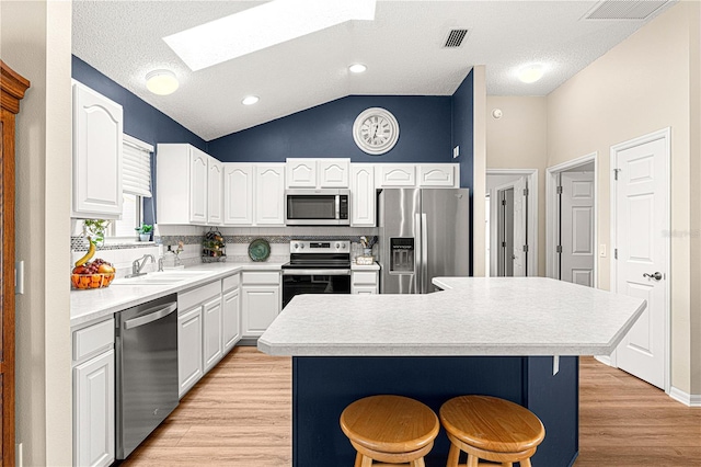 kitchen with a kitchen breakfast bar, a center island, sink, and stainless steel appliances