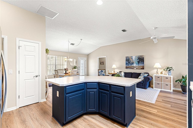 kitchen with a center island, hanging light fixtures, vaulted ceiling, and light hardwood / wood-style flooring