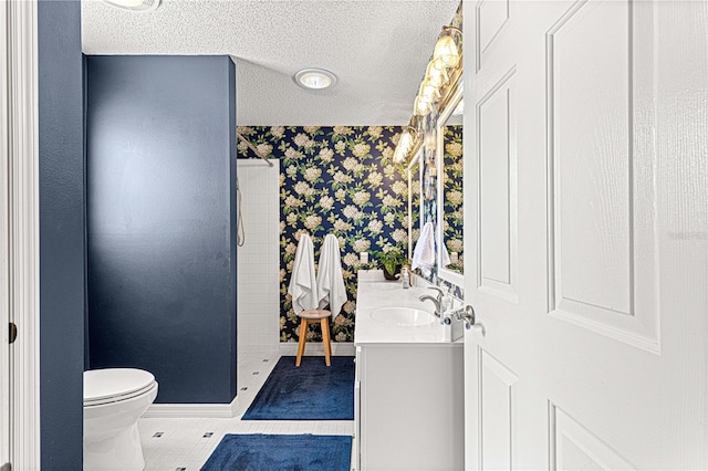 bathroom with tile patterned flooring, vanity, a textured ceiling, and toilet