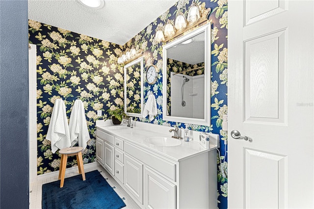 bathroom with a shower, vanity, and a textured ceiling