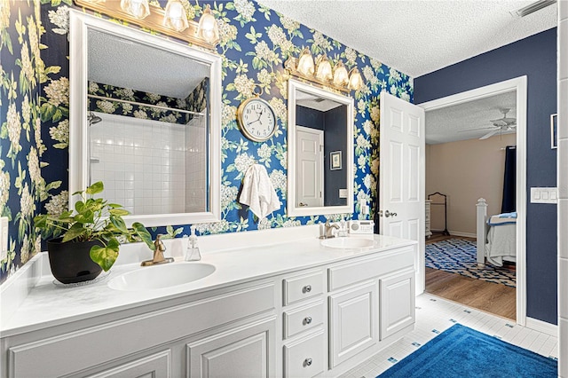 bathroom featuring a tile shower, a textured ceiling, hardwood / wood-style flooring, and ceiling fan