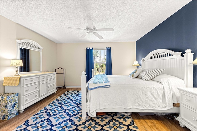 bedroom featuring a textured ceiling, ceiling fan, and dark hardwood / wood-style floors