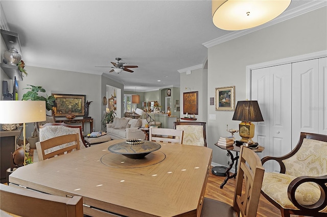 dining space featuring hardwood / wood-style flooring, ceiling fan, and crown molding