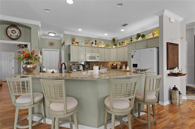 kitchen featuring light hardwood / wood-style floors, white appliances, a textured ceiling, and ornamental molding