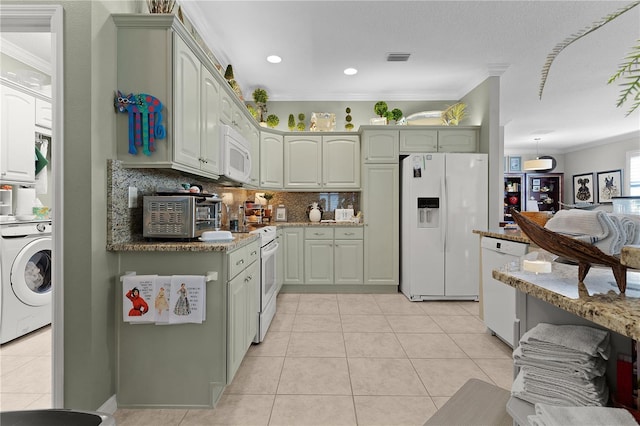 kitchen featuring washer / clothes dryer, white appliances, decorative backsplash, light tile patterned floors, and ornamental molding