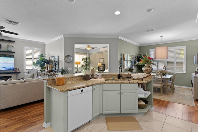 kitchen featuring white cabinets, sink, decorative light fixtures, light hardwood / wood-style flooring, and dishwasher