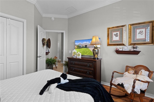 bedroom with hardwood / wood-style floors, crown molding, and a closet