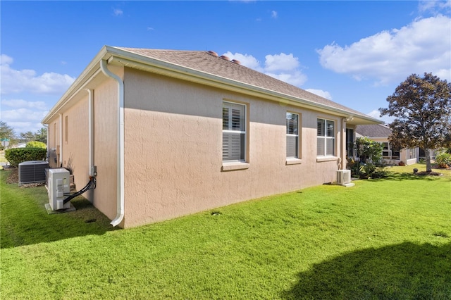 view of side of home featuring central air condition unit and a yard