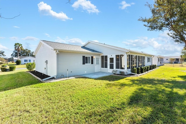 back of property featuring a sunroom, a yard, and a patio