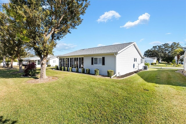 view of side of home with a lawn, a sunroom, and cooling unit