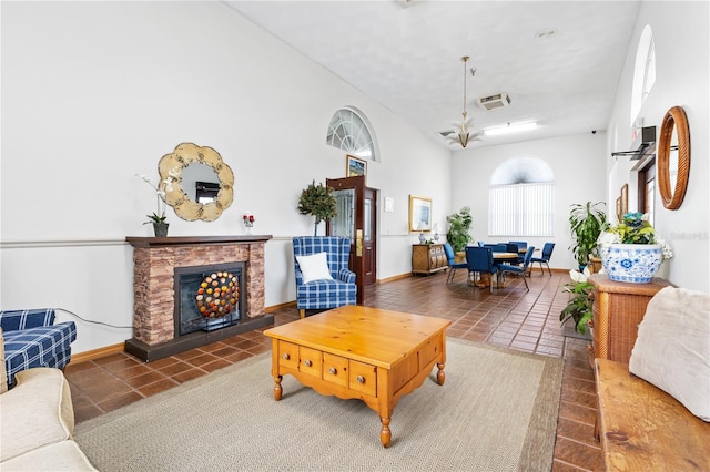 living room with a fireplace and a towering ceiling