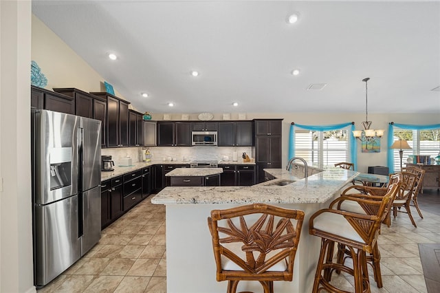 kitchen featuring a large island with sink, sink, a healthy amount of sunlight, and appliances with stainless steel finishes