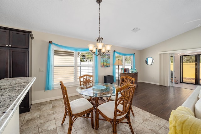 dining area featuring an inviting chandelier, lofted ceiling, and light hardwood / wood-style flooring