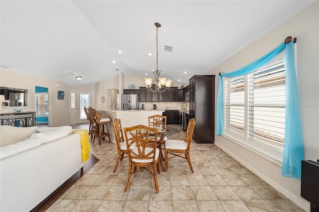 dining room with lofted ceiling, sink, and a chandelier