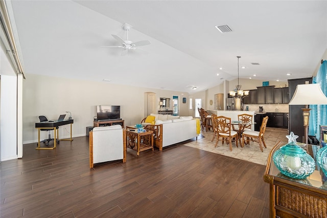 living room with ceiling fan with notable chandelier, dark wood-type flooring, and lofted ceiling