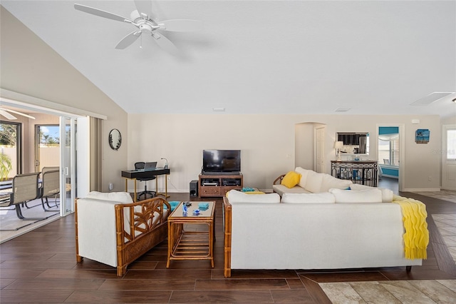 living room with ceiling fan, plenty of natural light, dark wood-type flooring, and vaulted ceiling