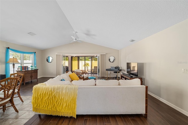 living room with plenty of natural light, wood-type flooring, and vaulted ceiling