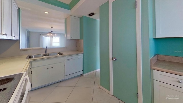 kitchen featuring white dishwasher, sink, pendant lighting, range, and white cabinetry