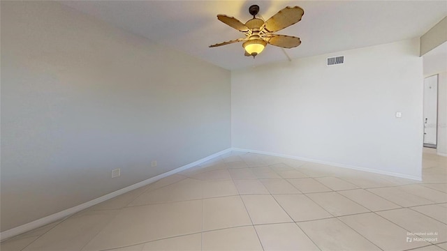 tiled spare room with ceiling fan