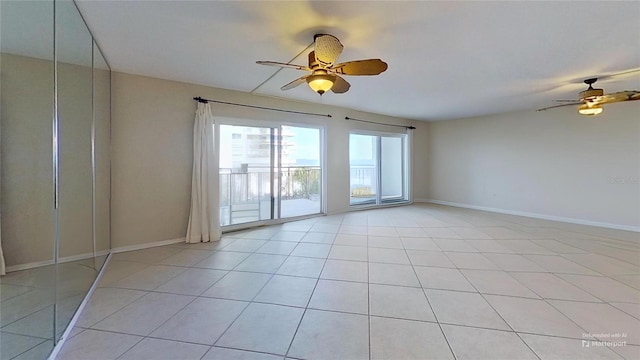 empty room with ceiling fan and light tile patterned floors