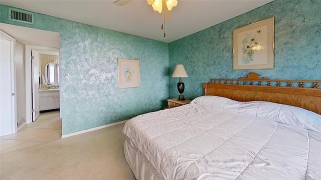 bedroom featuring connected bathroom, light colored carpet, and ceiling fan