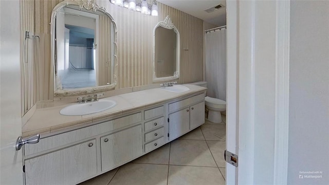 bathroom with tile patterned floors, vanity, toilet, and an inviting chandelier