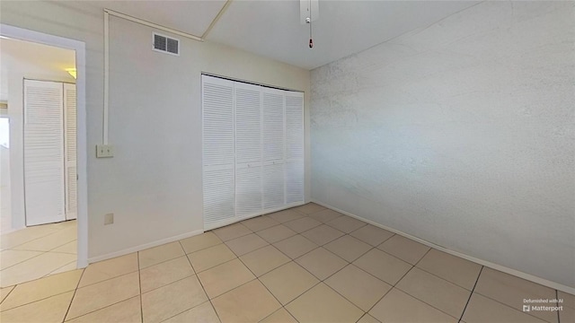 unfurnished bedroom with light tile patterned floors and a closet