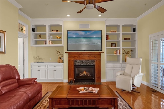 living room featuring crown molding, light hardwood / wood-style flooring, and ceiling fan