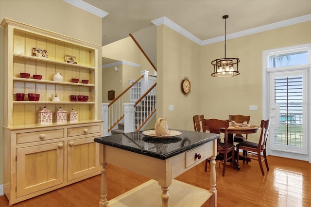 interior space featuring a notable chandelier, ornamental molding, and light hardwood / wood-style flooring