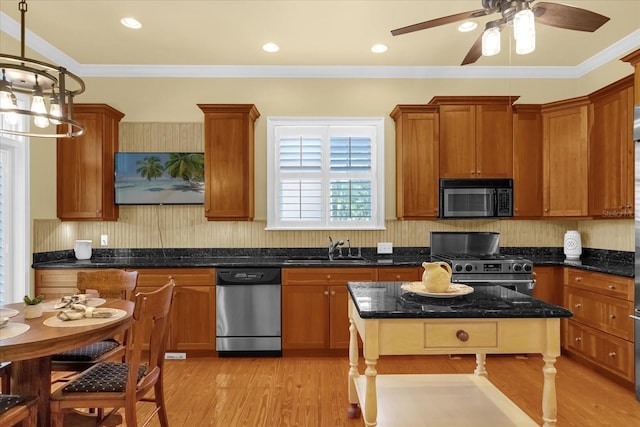 kitchen with sink, hanging light fixtures, light hardwood / wood-style flooring, appliances with stainless steel finishes, and ornamental molding