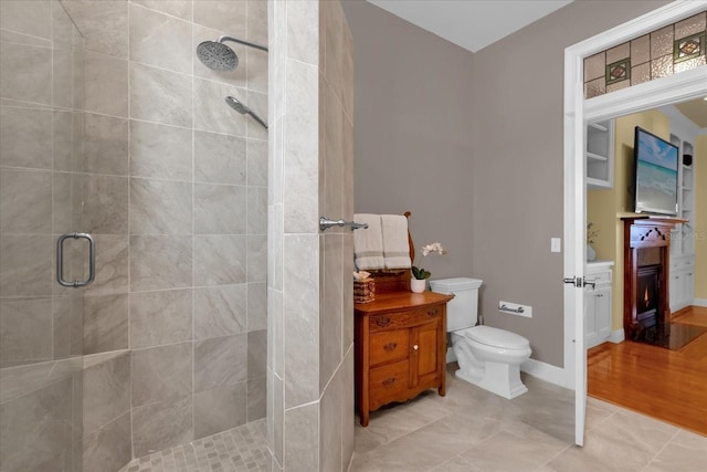 bathroom with tile patterned flooring, a shower with shower door, and toilet