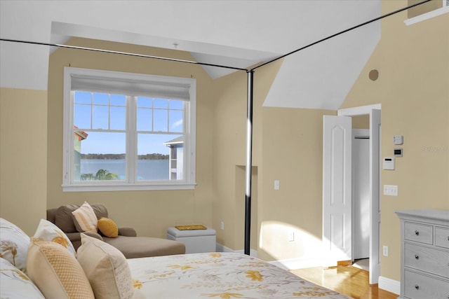 bedroom with a water view and light hardwood / wood-style floors