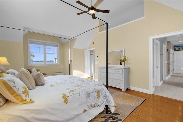 bedroom featuring a high ceiling, light hardwood / wood-style flooring, and ceiling fan