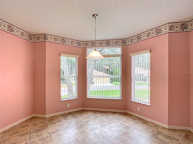 spare room featuring a textured ceiling and plenty of natural light