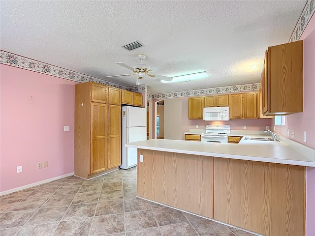 kitchen featuring kitchen peninsula, a textured ceiling, white appliances, and sink