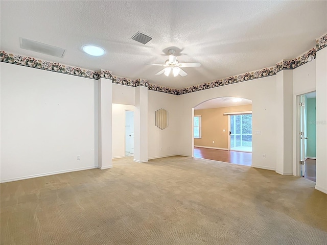 empty room featuring carpet flooring, ceiling fan, and a textured ceiling