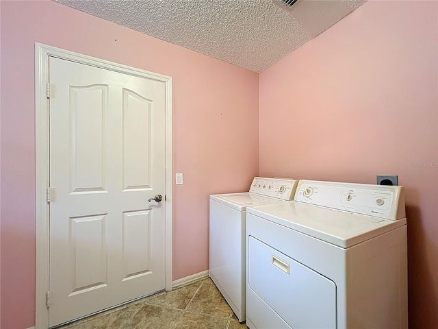 laundry area with separate washer and dryer, a textured ceiling, and light tile patterned floors