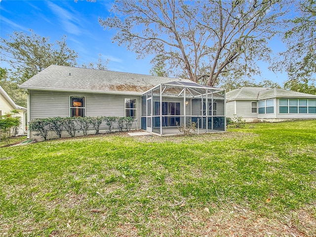 rear view of house featuring a lanai and a lawn