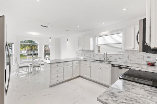 kitchen with kitchen peninsula, sink, and white cabinets