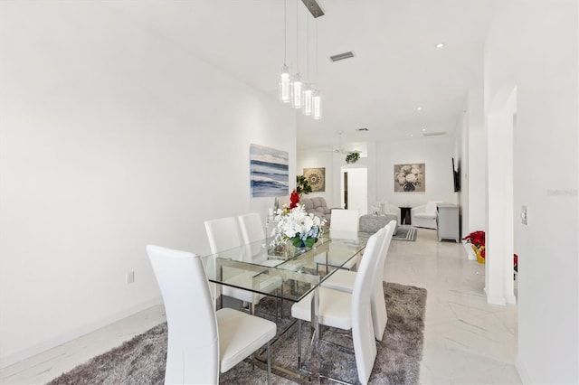 dining room with ceiling fan and a high ceiling