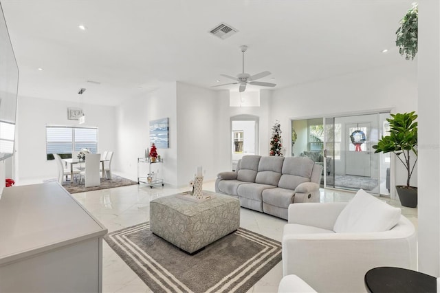 living room with a wealth of natural light, french doors, and ceiling fan