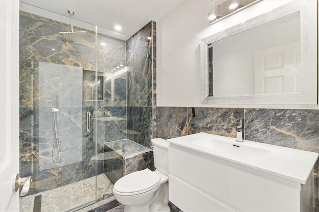 bathroom featuring vanity, a shower with shower door, tile walls, and toilet