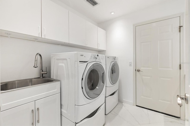 washroom with washer and dryer, cabinets, and sink